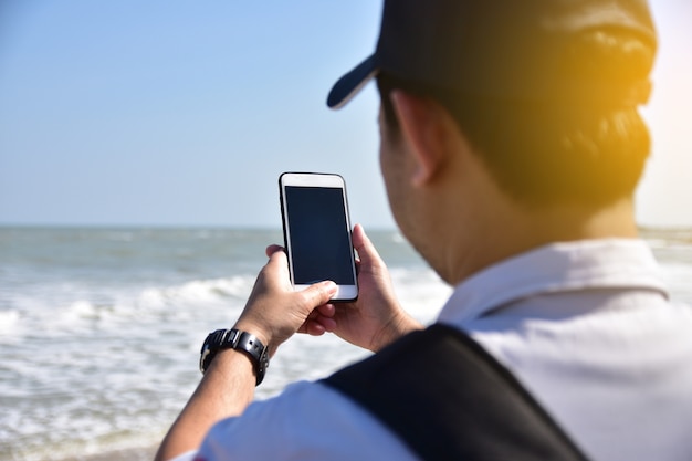 Ludzie trzymają mobilnego mądrze telefon przy dennym tłem