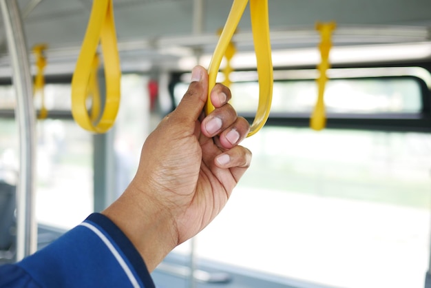 ludzie trzymający się klamki w autobusie