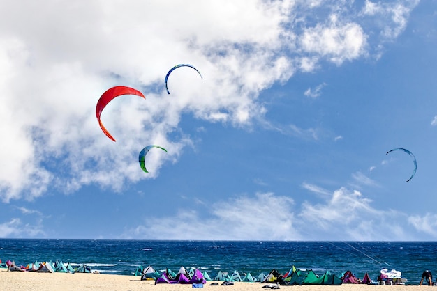 Ludzie uprawiający kitesurfing na plaży Los Caños de Meca, obok latarni morskiej Trafalgar w Kadyksie.