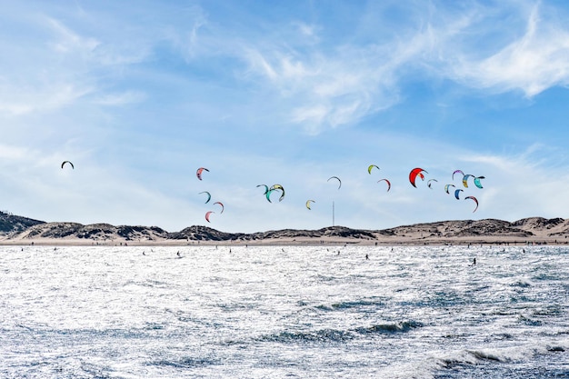 Ludzie uprawiający kitesurfing na plaży Los Caos de Meca, obok latarni morskiej Trafalgar.