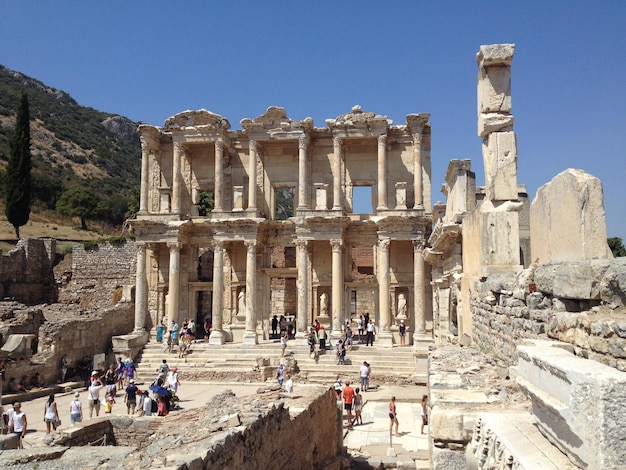 Zdjęcie ludzie w bibliotece celsus na czyste niebieskie niebo