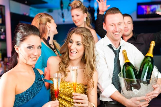 Zdjęcie ludzie w klubie lub barze piją szampana
