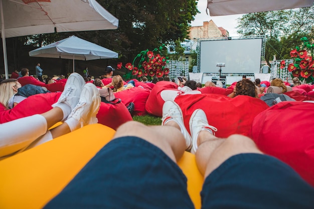 Ludzie w miejskim parku publicznym oglądają film w kinie na świeżym powietrzu