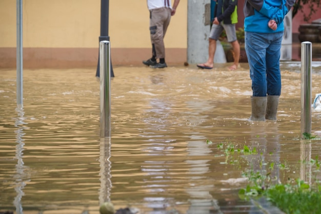 Ludzie w powodziach na ulicach miast po ulewnym deszczu, ciężkiej katastrofie pogodowej