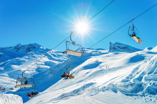 Ludzie w wyciągach krzesełkowych w ośrodku narciarskim na lodowcu Hintertux w Zillertal w Tyrolu w Austrii w zimie w Alpach. Wyciągi krzesełkowe w alpejskich górach ze śniegiem. Zjazdowa zabawa. Rodzinne wakacje. Białe stoki.