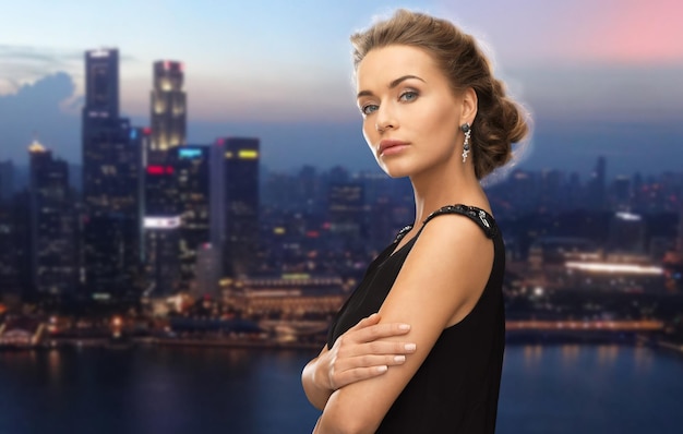 ludzie, wakacje, życie nocne i koncepcja glamour - piękna kobieta nosząca kolczyki na tle nocnego miasta singapur