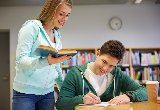 ludzie, wiedza, edukacja i koncepcja szkoły - zadowoleni uczniowie z książką przygotowującą do egzaminów w bibliotece