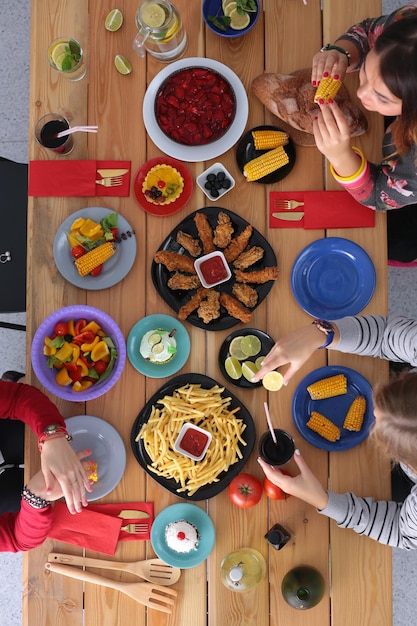 Ludzie z napojami siedząc przy stole Jedzenie na stole Jedzenie na stole Ludzie jedzą fast foody