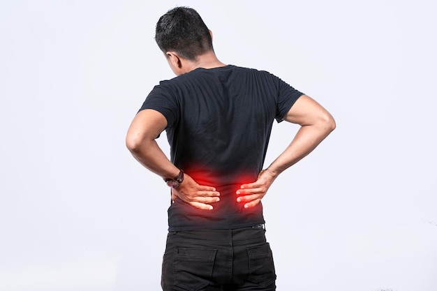 Zdjęcie ludzie z problemami kręgosłupa mężczyzna z problemami z plecami na odosobnionym tle koncepcja problemów lędźwiowych obolały mężczyzna z bólem pleców