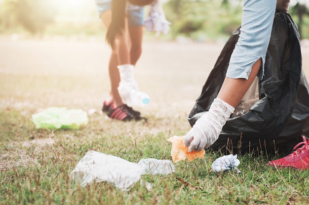 Ludzie zbierają śmieci i wkładają je do plastikowej czarnej torby