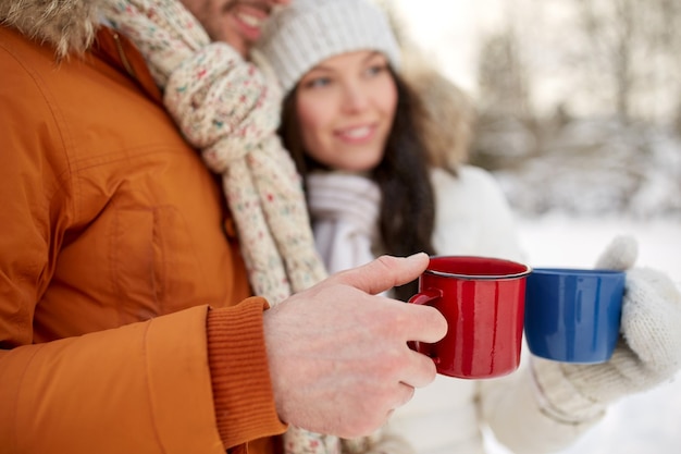 ludzie, zima, napoje i koncepcja sezonu - zbliżenie szczęśliwej pary trzymającej filiżanki gorącej herbaty