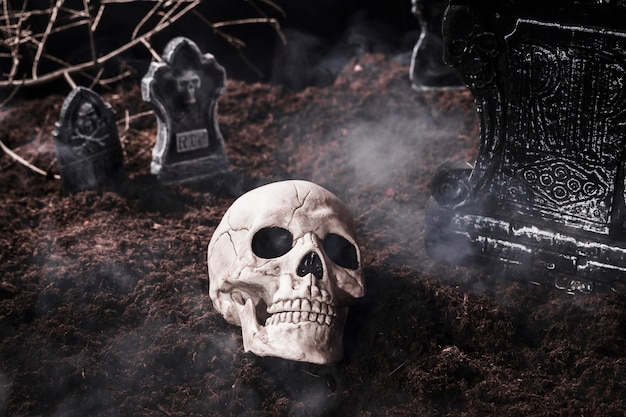 Zdjęcie ludzka czaszka w dymie przy halloweenowym cmentarzem