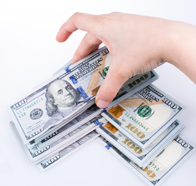 Ludzka ręka trzyma banknoty dolara amerykańskiego na białym tle