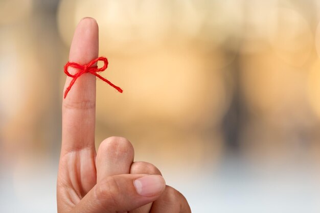 Zdjęcie Łuk z czerwonej nici na ludzkim palcu