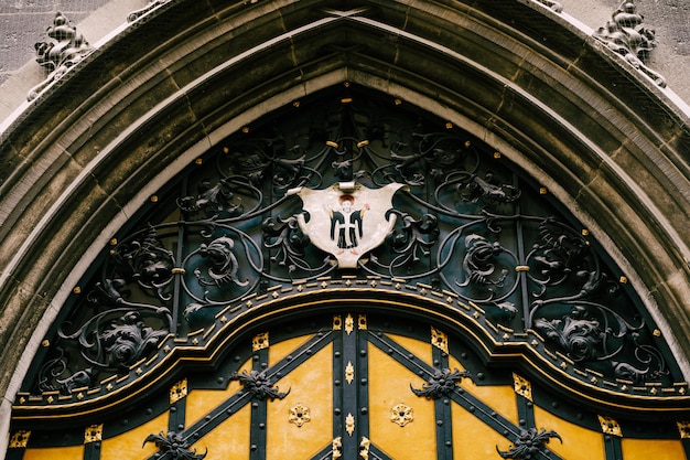 Łukowe Drzwi Z Elementami Wystroju Z Kutego żelaza I Herbem Z Aniołem W Starym Budynku