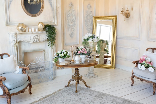 Luksusowe, bogate wnętrze salonu w beżowym pastelowym kolorze z antycznymi, drogimi meblami w stylu barokowym. ściany ozdobione sztukaterią i freskami