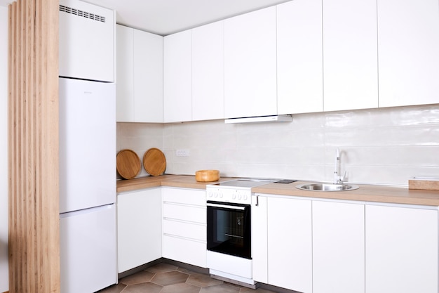 Luksusowe i nowoczesne wnętrze kuchni w kolorze białym z elementami drewnianymi