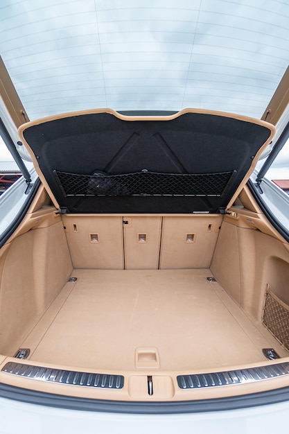 Luksusowe wnętrze samochodu. Beżowe wygodne siedzenia, kierownica, deska rozdzielcza, klimatyzacja, prędkościomierz, wyświetlacz, oświetlenie do dekoracji drewna