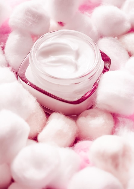 Luksusowy krem do twarzy dla wrażliwej skóry i różowych wacików na tle kosmetyków spa i naturalnych produktów marki kosmetycznej do pielęgnacji skóry