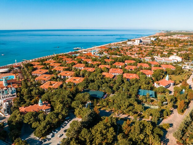 Zdjęcie luksusowy kurort na plaży z basenem, krzesłami plażowymi i palmami.