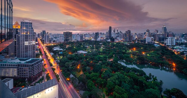 Zdjęcie lumpini park i miasto bangkok z zachodem słońca na dachu bar i restauracja