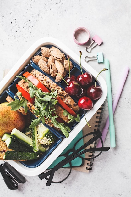 Lunch Box Z Kanapkami, Owocami, Przekąskami, Notatnikiem, Ołówkami I Szkolnymi Przedmiotami, Widok Z Góry.