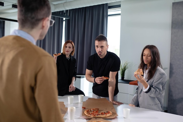 Lunch w biurze Ekipa pracowników biura podczas przerwy je pizzę