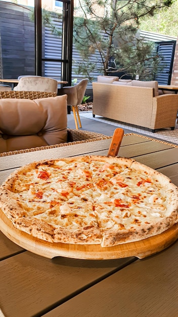Lunch w letniej kawiarni Pizza na stojaku na drewnianym stole