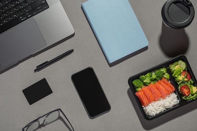 Lunch w pracy Szary pulpit z notatnikiem w laptopie i jedzeniem
