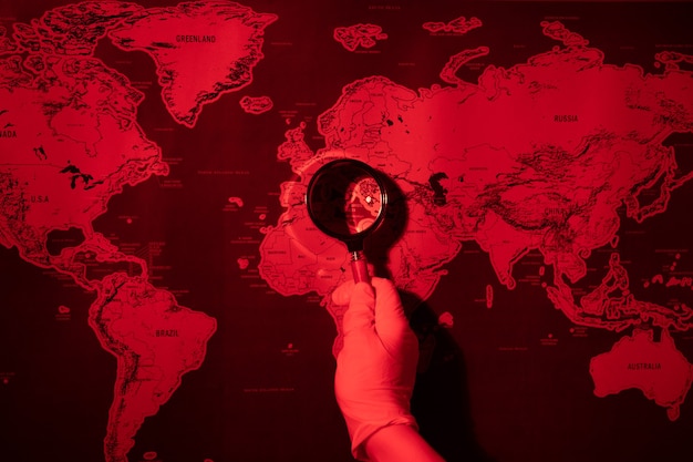 Lupa na mapie stonowanych czerwony, koncepcja epidemii świata