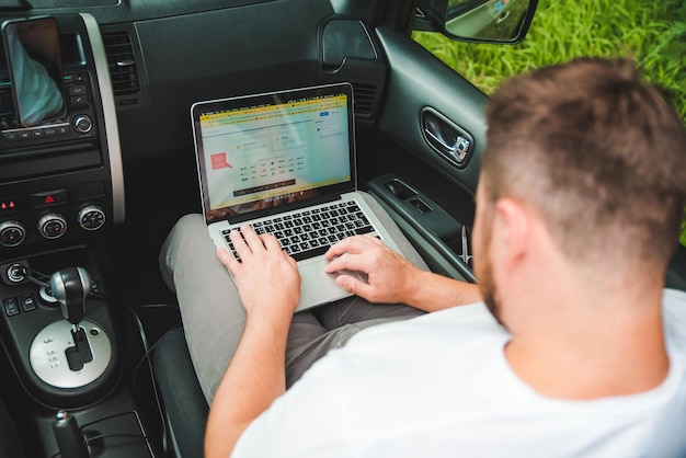 LWÓW UKRAINA 22 sierpnia 2018 młody dorosły mężczyzna pracujący w samochodzie na laptopie