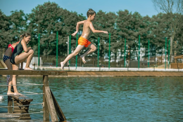 LWÓW UKRAINA 26 maja 2019 dzieciak skaczący z molo do wody jeziora