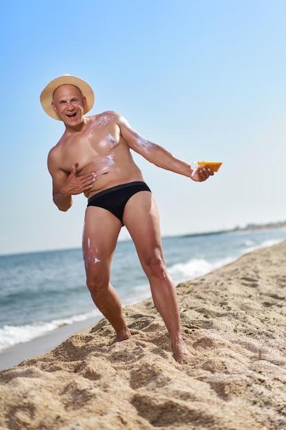 Łysy mężczyzna na plaży nad morzem na wakacjach