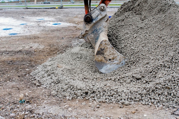 Łyżka do napełniania koparki półsuchym betonem na budowie