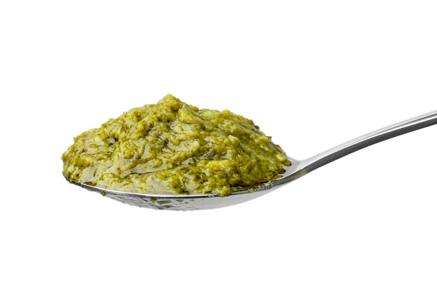 Łyżka z zielonym włoskim pesto na białym tle