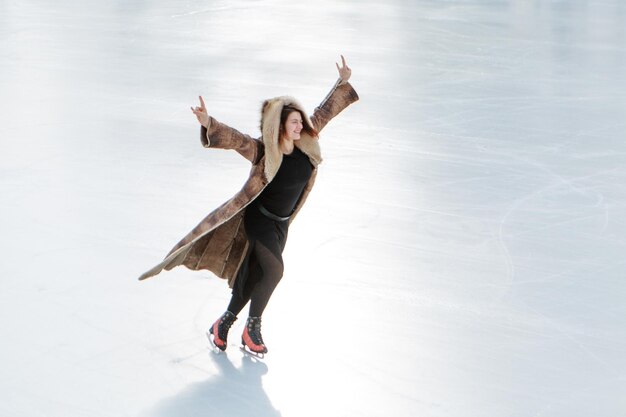 Zdjęcie Łyżwiarka figurowa na lodzie. dziewczyna jeździ na łyżwach. lód pod gołym niebem. zimą bez makijażu, czerwone policzki