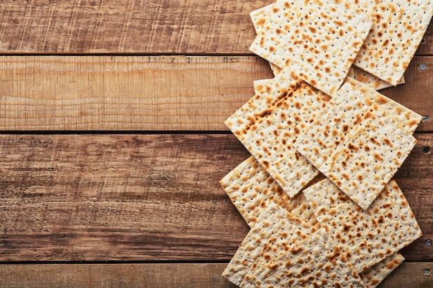 Zdjęcie maca. tradycyjny rytualny chleb żydowski na starym drewnianym tle rustykalnym. jedzenie paschy. pesach żydowskie święto obchodów paschy.