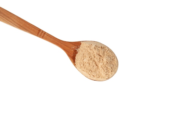 Maca w proszku w drewnianej łyżce na białym tle zbliżenie Maca żelowana mąka Peruwiański superfood