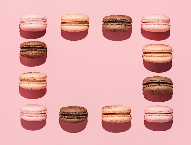 Macarons na różowej przestrzeni kopii twarde światło