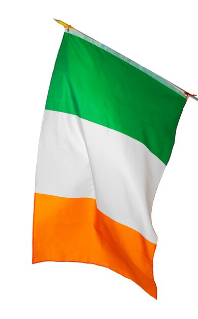 Macha flagą narodową Irlandii na białym tle na białej ścianie