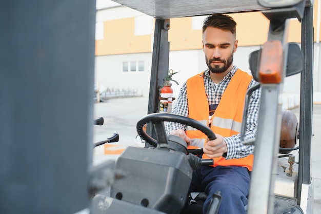 Machający kierowca wózka widłowego w magazynie firmy transportowej podczas jazdy wózkiem widłowym