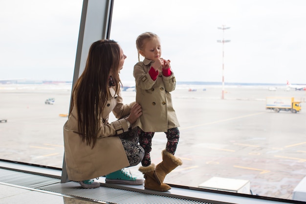Macierzysta I Mała Córka Patrzeje Przez Okno Przy Lotniskowym Terminal