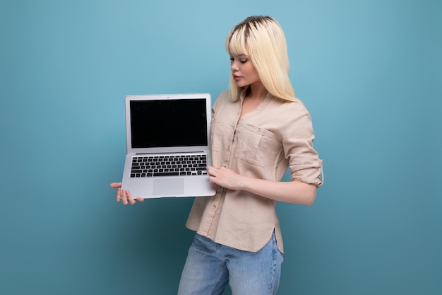Mądra blond młoda biznesowa kobieta demonstruje pracę na laptopie