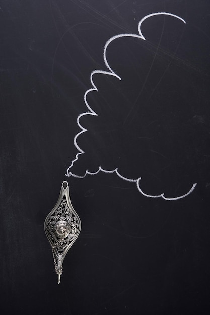 Magiczna lampa Alladyna na tablicy z rysunkiem dymu