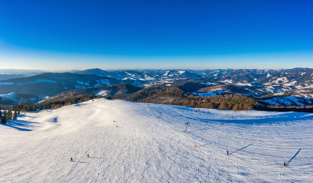 Magiczna zimowa panorama pięknych ośnieżonych stoków ośrodka narciarskiego w Europie w słoneczny, bezwietrzny mroźny dzień. Koncepcja aktywnego wypoczynku zimą