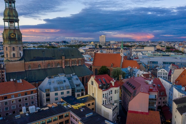 Magiczny burzliwy zachód słońca nad starówką w Rydze - stolicy Łotwy. Na niebie tworzą się chmury Stormu. Piękna Ryga o zachodzie słońca.