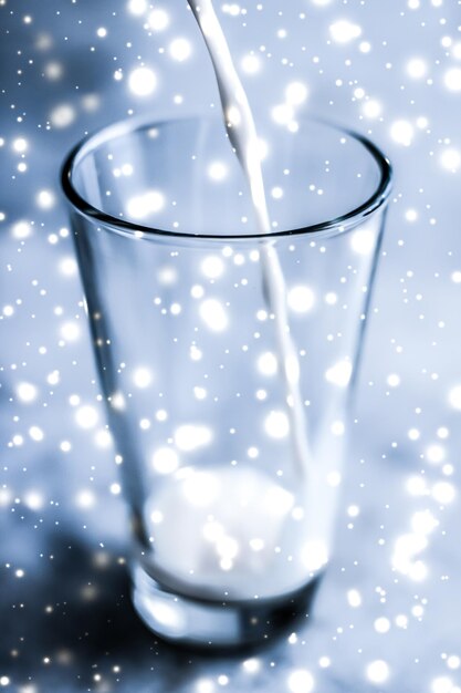 Zdjęcie magiczny świąteczny napój nalewający organiczne mleko bez laktozy do szklanki na marmurowym stole