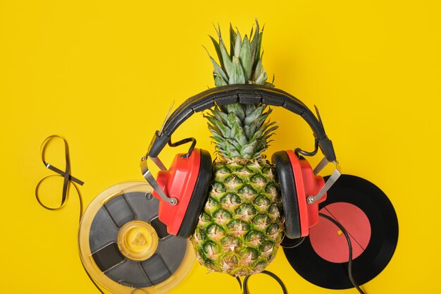 Magnetyczna Taśma Audio, Winyl I Ananas W Czerwonych Słuchawkach Retro Na żółtym Tle, Widok Z Góry