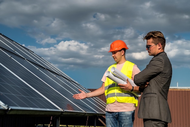 Majster i inżynier pracują podczas sprawdzania i naprawy koncepcji paneli fotowoltaicznych słonecznej zielonej energii