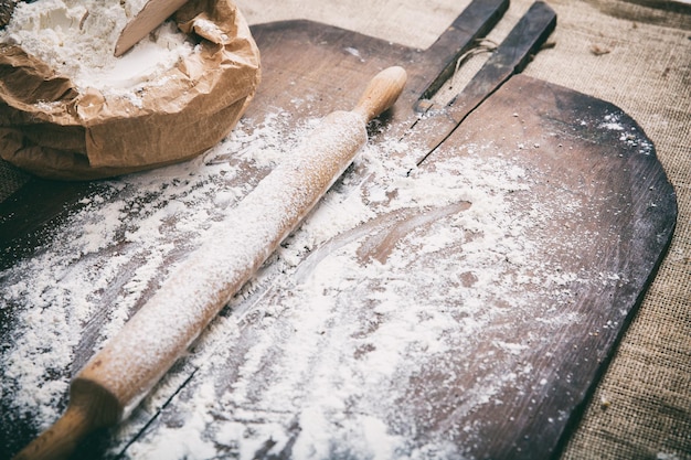 Mąka i wałek do ciasta na drewnianej powierzchni
